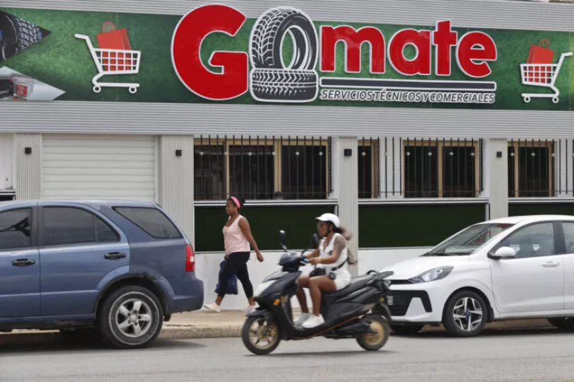 Personas pasan frente al local comercial Gomate en La Habana (Cuba).