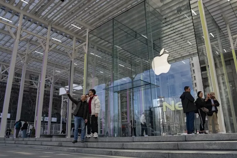 Multitud de personas tomando fotografías en la entrada de la icónica tienda de Apple en la Quinta Avenida de Nueva York.