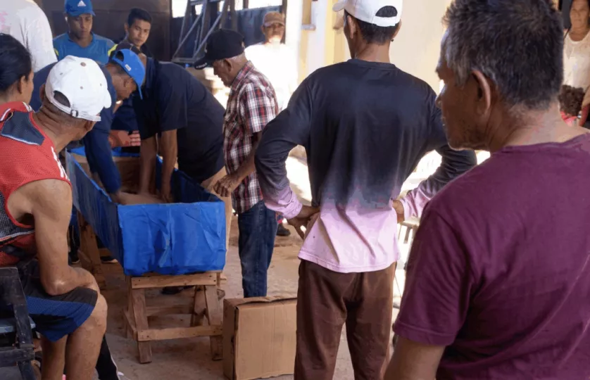 Familiares y vecinos en Cuba armando de forma rudimentaria un ataúd utilizando pedazos de cartón.