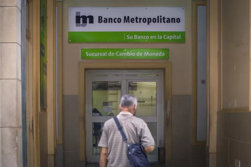 Edificio de banco en Cuba con personas en el exterior.