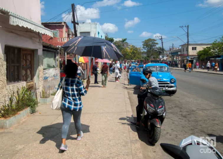 Una mujer se protege del sol con una sombrilla en La Habana.
