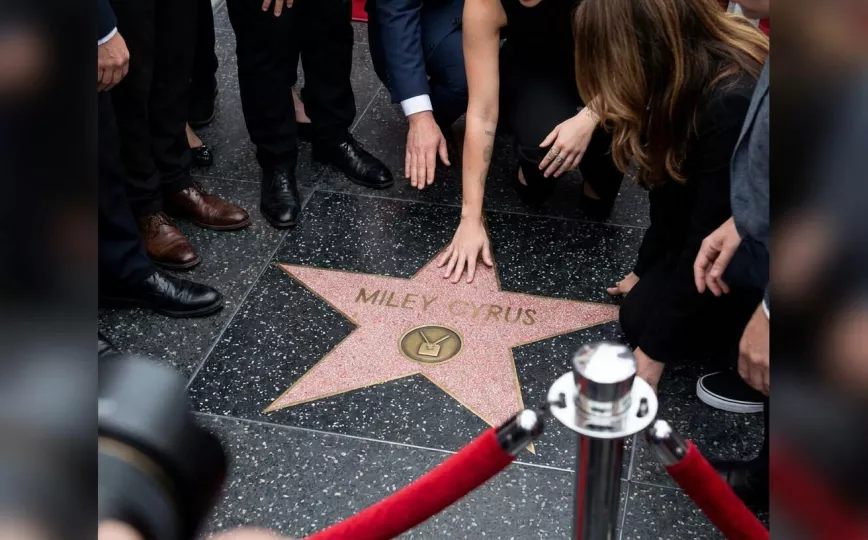 Miley Cyrus posando junto a su nueva estrella en el Paseo de la Fama de Hollywood rodeada de sus allegados.