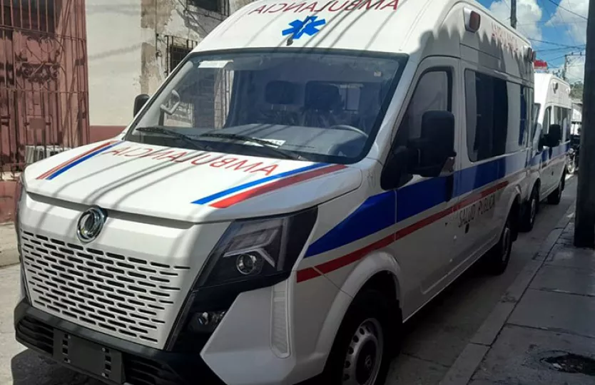 Una fila de nuevas ambulancias de color blanco y azul estacionadas al aire libre.