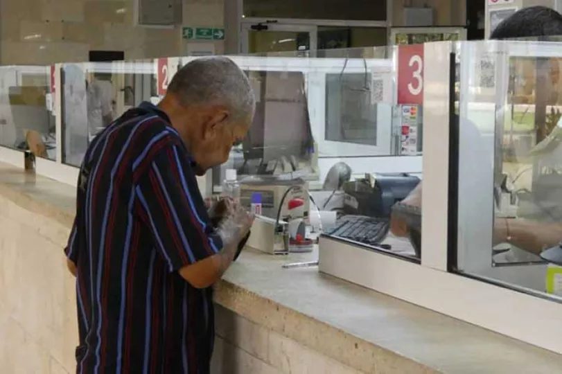 Imagen de jubilados cubanos utilizando una tarjeta magnética en un cajero automático.