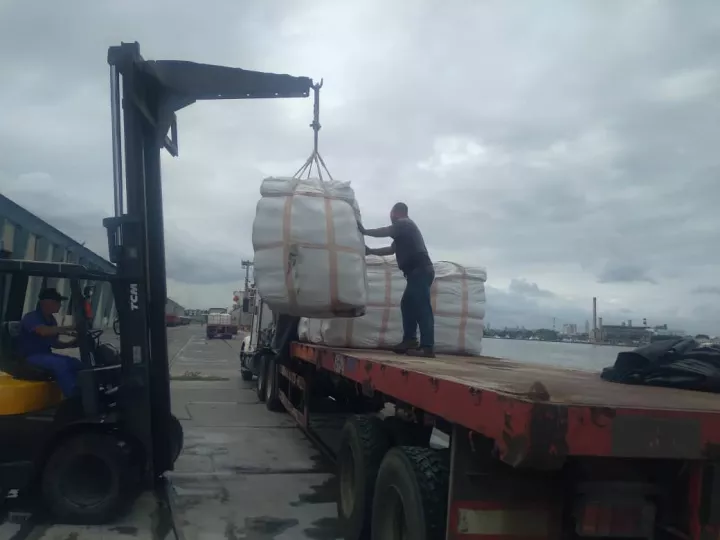 Sacos de cemento apilados en un almacén portuario.