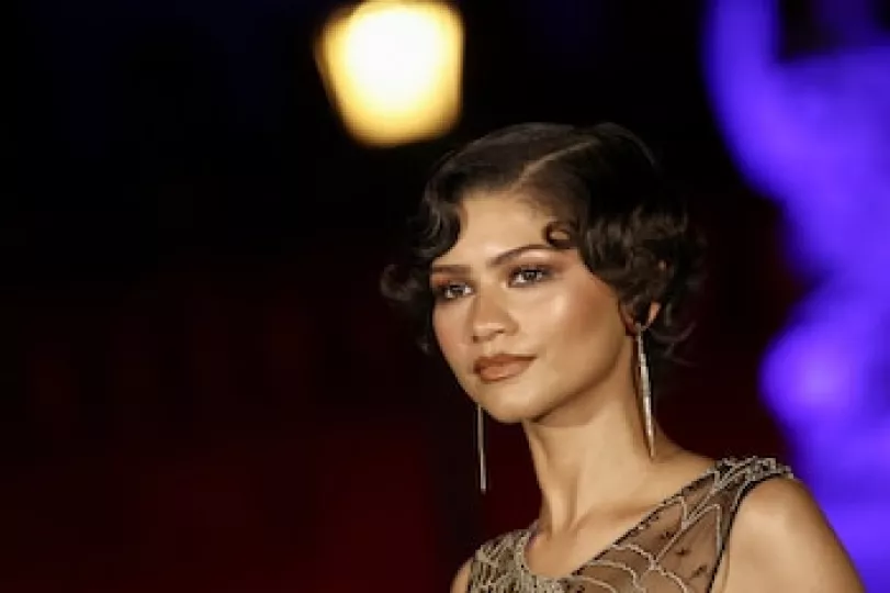 Zendaya posando en un evento promocional cinematográfico.