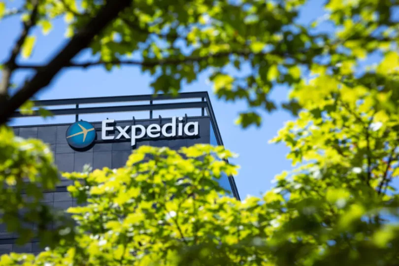 Logotipo de la agencia de viajes Expedia junto a una representación de edificios hoteleros en el contexto de litigios legales.
