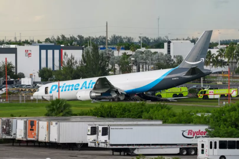 Avión de carga de Amazon accidentado en una zona adyacente a la pista del Aeropuerto Internacional de Miami tras impactar contra vehículos.