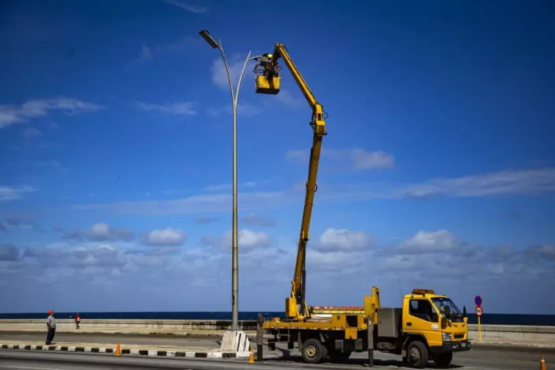 Imagen de una brigada de linieros trabajando en postes eléctricos en Cuba.
