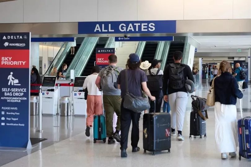 Punto de control de seguridad en un aeropuerto estadounidense donde se observa personal de la TSA y viajeros.