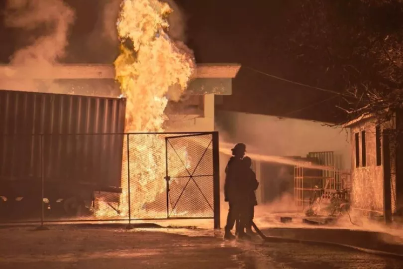 Bomberos trabajando en la extinción de un incendio en un contenedor de combustible en una planta industrial de Manzanillo.