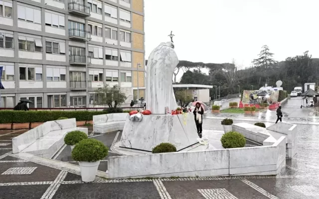 Continúan rezos de los fieles frente a una estatua del Papa Juan Pablo II en el exterior del hospital Agostino Gemelli.