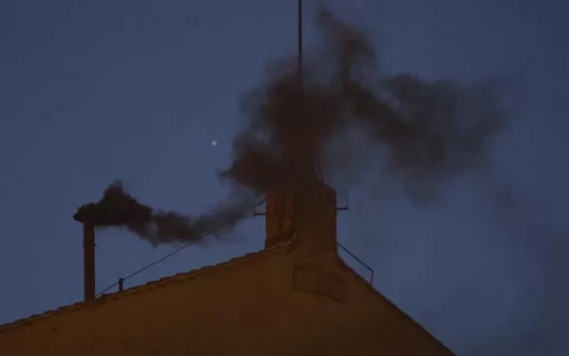 El humo negro saliendo de la chimenea en el techo de la Capilla Sixtina en el primer día del cónclave para elegir un nuevo Papa en la Ciudad del Vaticano.