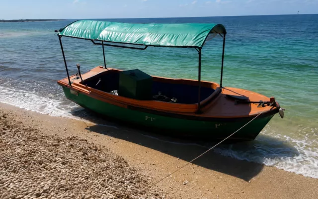Embarcación de madera precaria llegando a las costas de Key West con migrantes a bordo.