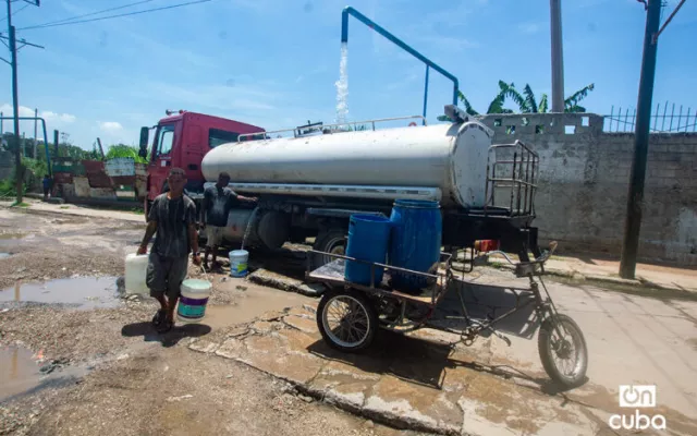 Una pipa de agua y personas recolectando agua en La Habana durante la crisis de suministro.