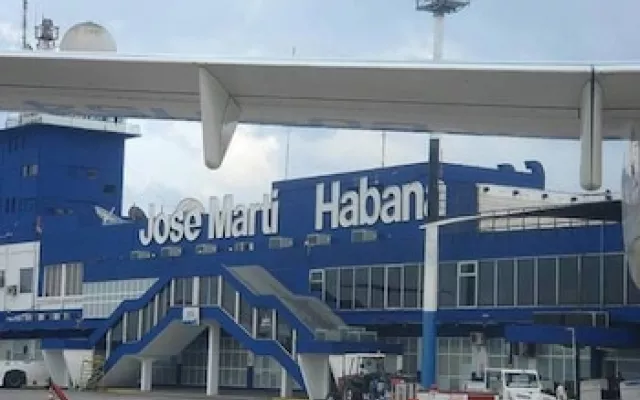 Vista exterior de una torre de control y pista de aterrizaje en un aeropuerto cubano.