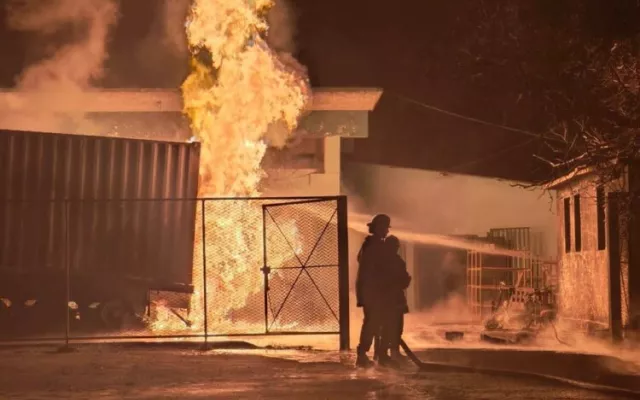 Bomberos trabajando en la extinción de un incendio en un contenedor de combustible en una planta industrial de Manzanillo.