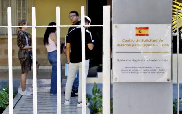 Personas haciendo fila en el exterior de la nueva sede consular de España en el municipio Playa, La Habana.